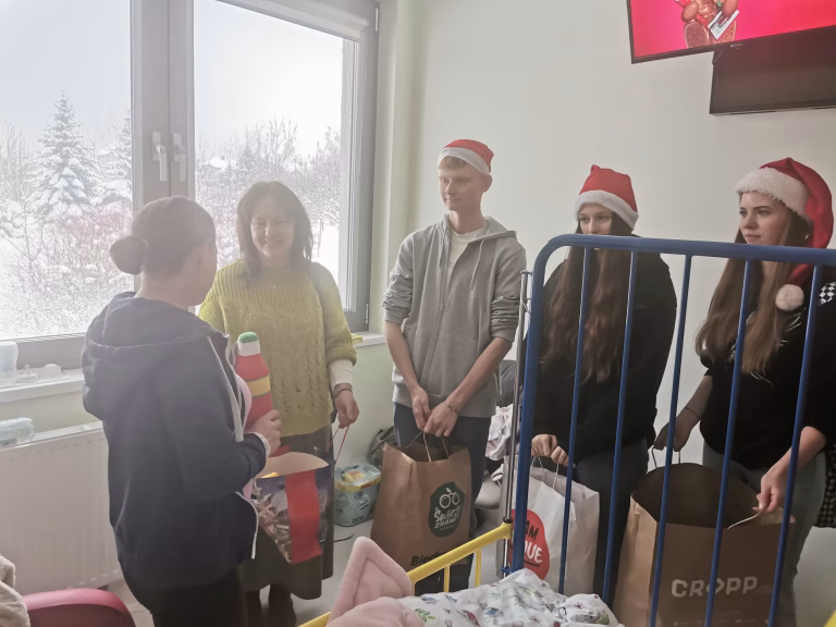 młodzież z prezentami i czapkami Mikołaja na oddziale