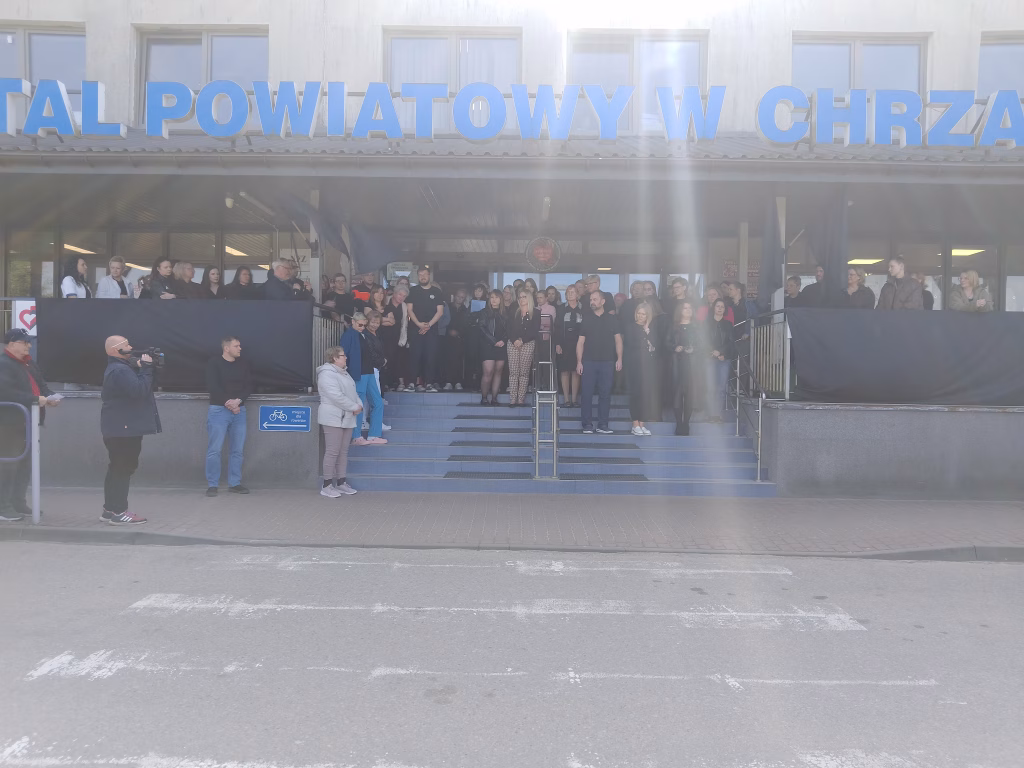 Protestujący w czarnych koszulkach przeciwko niedofinansowaniu systemu przed Szpitalem Powiatowym w Chrzanowie